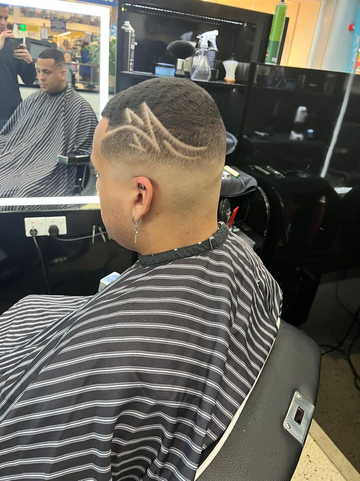 Skin fade with a freehand hair design cut into the side